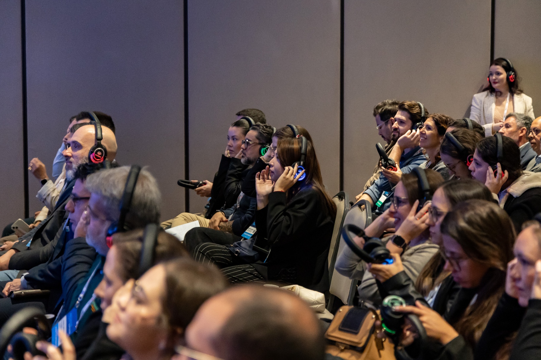 Público atento com headsets de tradução simultânea